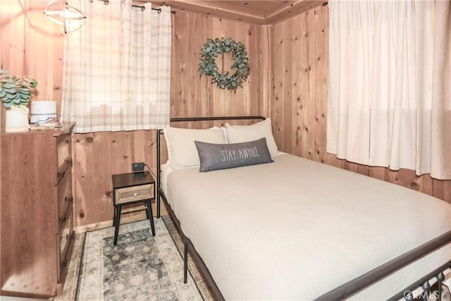 bedroom featuring wooden walls