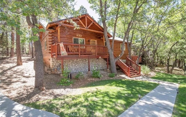 view of front of property with a deck, a front yard, log exterior, and stairway