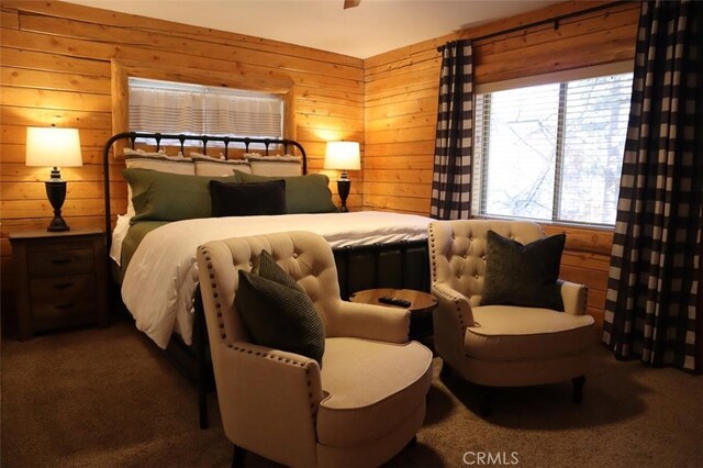 bedroom featuring wooden walls and carpet flooring