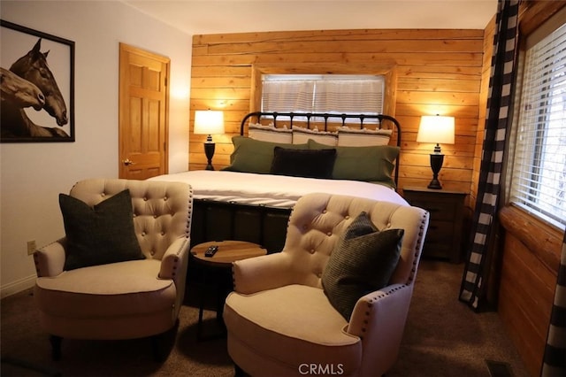 bedroom featuring carpet flooring, visible vents, and wooden walls