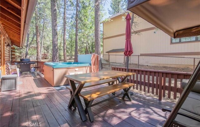 deck featuring a grill and a hot tub