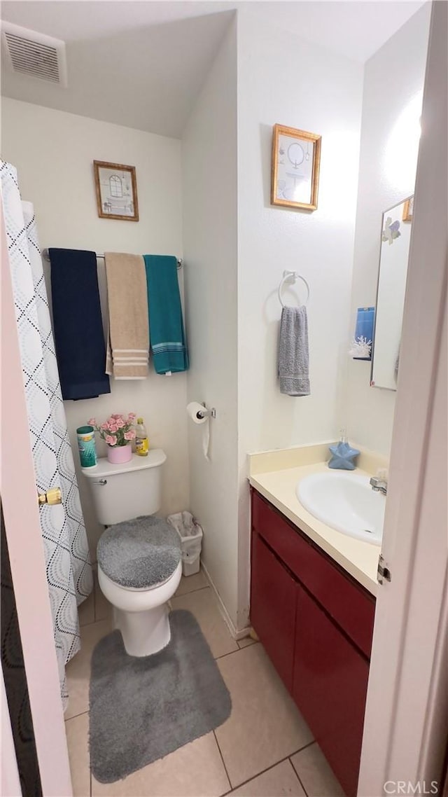 bathroom with toilet, tile patterned floors, and vanity