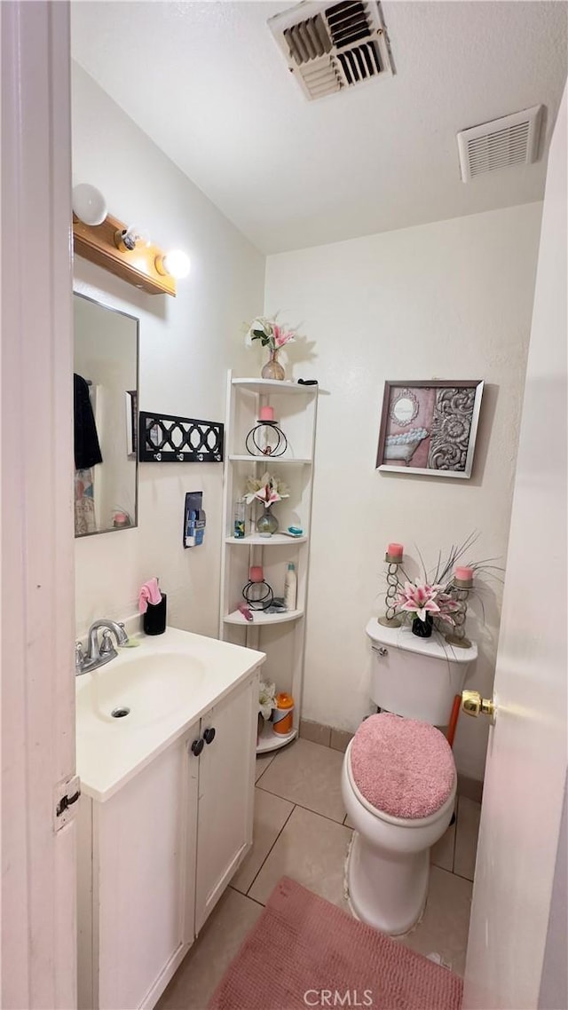 bathroom with toilet, tile patterned floors, and vanity