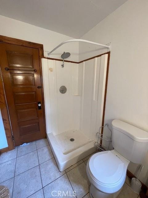 bathroom featuring walk in shower, tile patterned flooring, and toilet