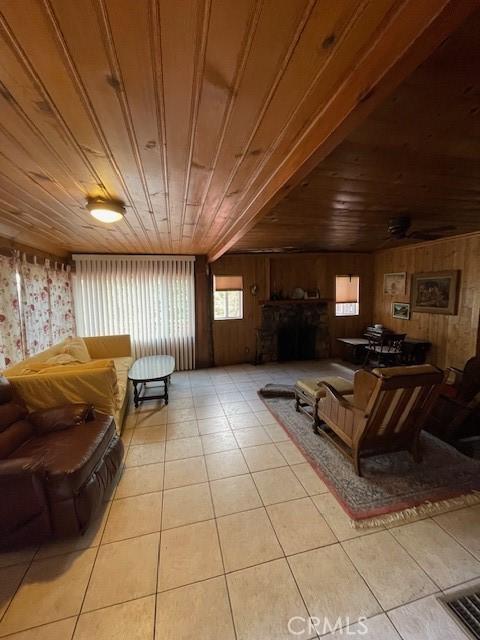 living room with wooden walls, light tile patterned floors, and wood ceiling