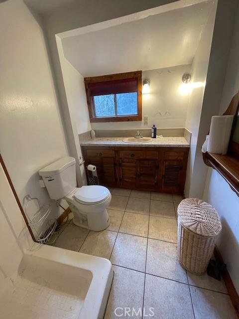 bathroom with toilet, tile patterned floors, and vanity