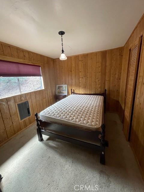 carpeted bedroom with wood walls