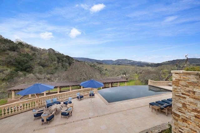 view of swimming pool with a pergola, a mountain view, and a patio