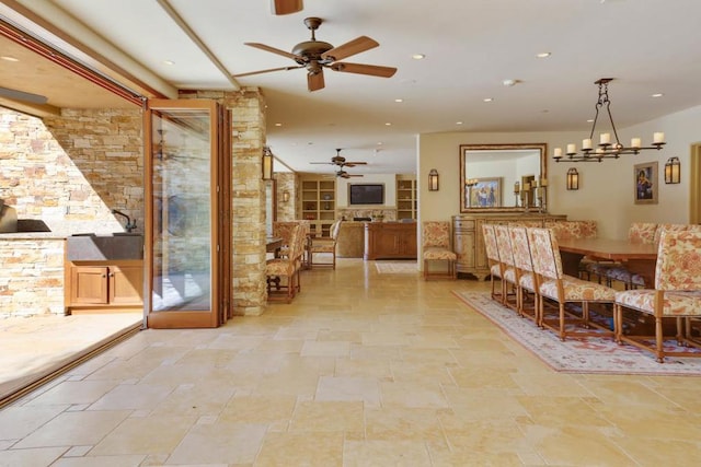 unfurnished dining area featuring ceiling fan with notable chandelier and built in features