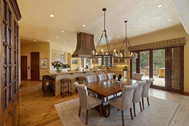 dining room featuring french doors, a chandelier, and light hardwood / wood-style floors