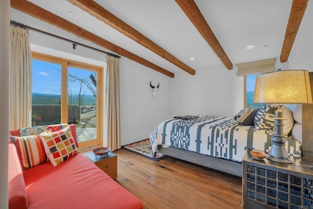 bedroom with beamed ceiling and wood-type flooring