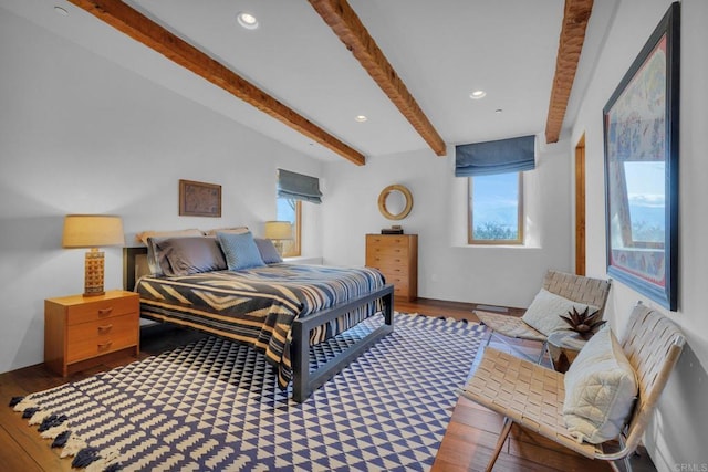 bedroom with hardwood / wood-style floors and beamed ceiling