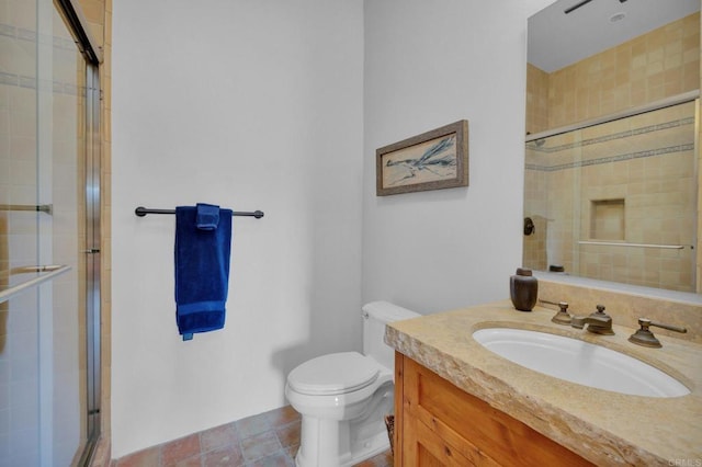 bathroom featuring a shower with door, vanity, and toilet