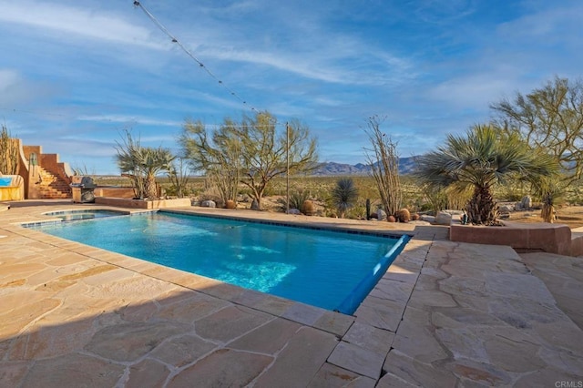 view of swimming pool featuring a mountain view, an in ground hot tub, and a patio