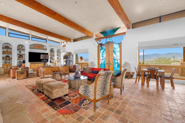 living room featuring beamed ceiling, built in shelves, and a mountain view