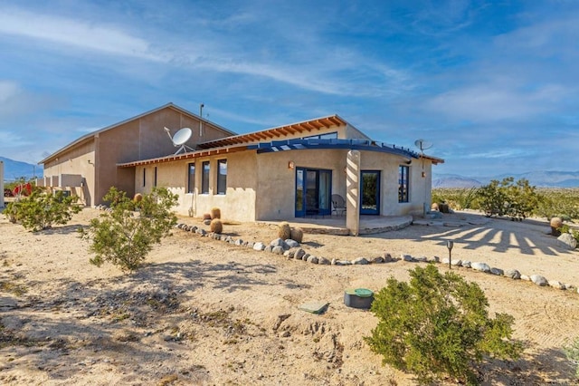 back of house featuring a mountain view and a patio