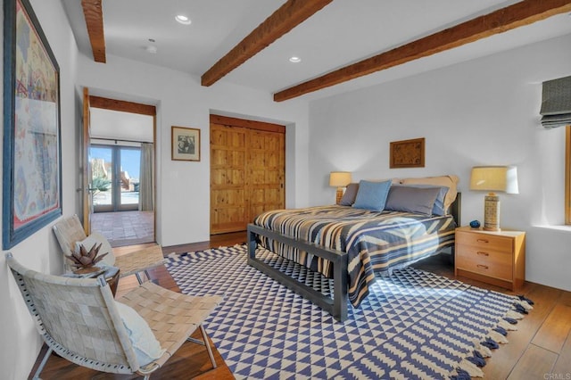 bedroom with beamed ceiling, a closet, french doors, and light hardwood / wood-style flooring