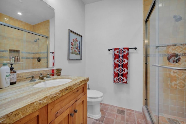 bathroom with vanity, toilet, and a shower with door