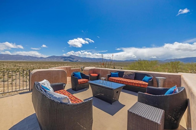 view of patio featuring a mountain view and an outdoor living space with a fire pit