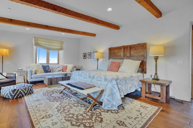 bedroom featuring hardwood / wood-style floors and beam ceiling