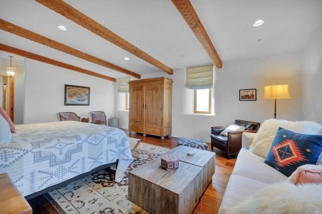 bedroom featuring beam ceiling and light hardwood / wood-style flooring