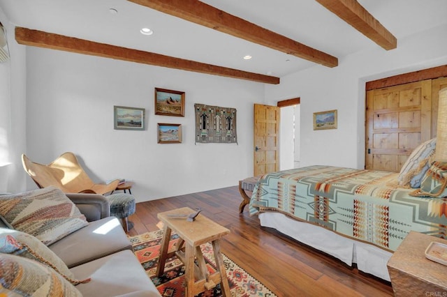 bedroom featuring wood-type flooring and beam ceiling