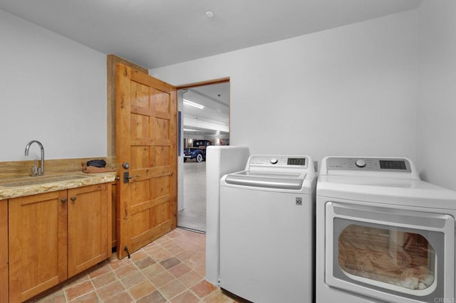 laundry area featuring cabinets, sink, and washing machine and dryer