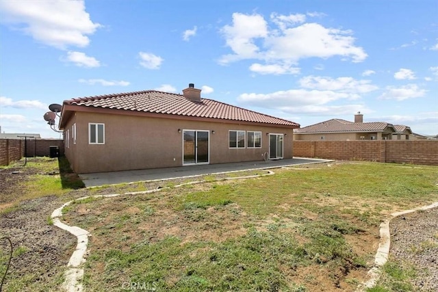 back of house with a patio area and a lawn