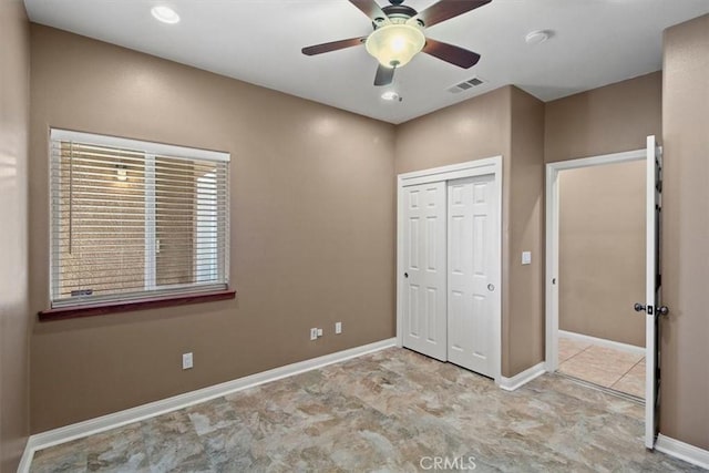 unfurnished bedroom with ceiling fan and a closet