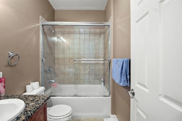 full bathroom with enclosed tub / shower combo, vanity, and toilet