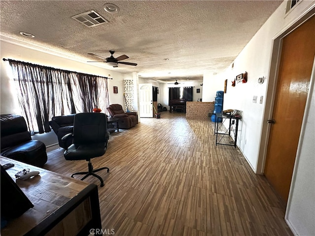 living room with a textured ceiling, hardwood / wood-style floors, and ceiling fan