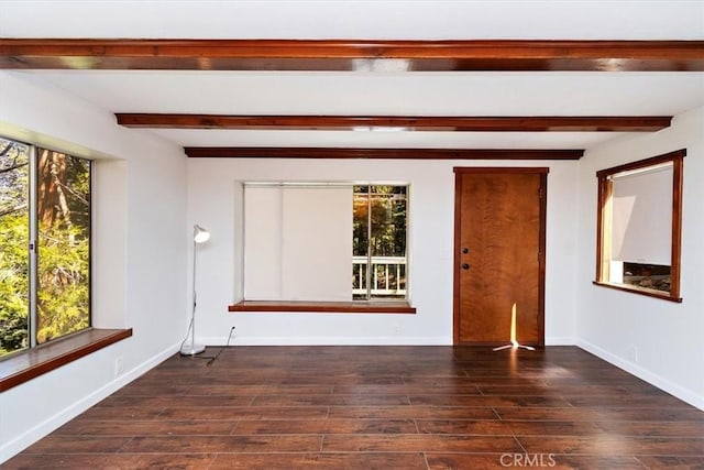 unfurnished room featuring dark wood-type flooring, beam ceiling, and a healthy amount of sunlight