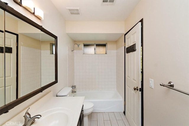 full bathroom with toilet, tiled shower / bath combo, and vanity