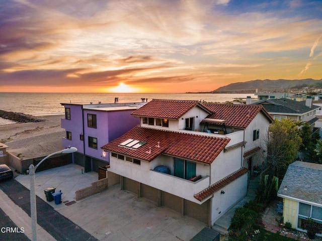 aerial view at dusk featuring a water view