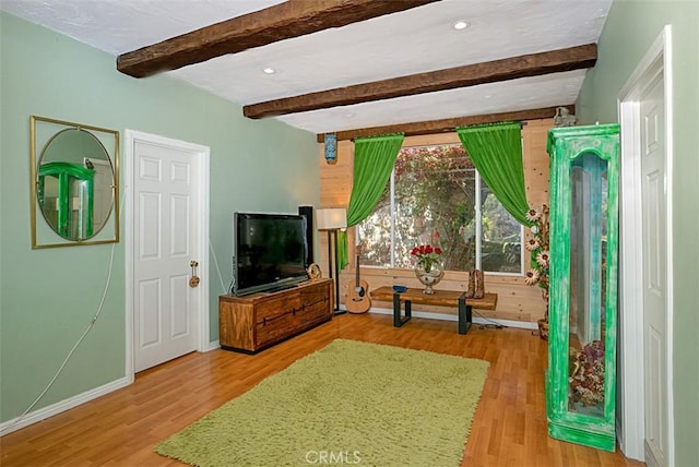 living room with light hardwood / wood-style flooring and beamed ceiling