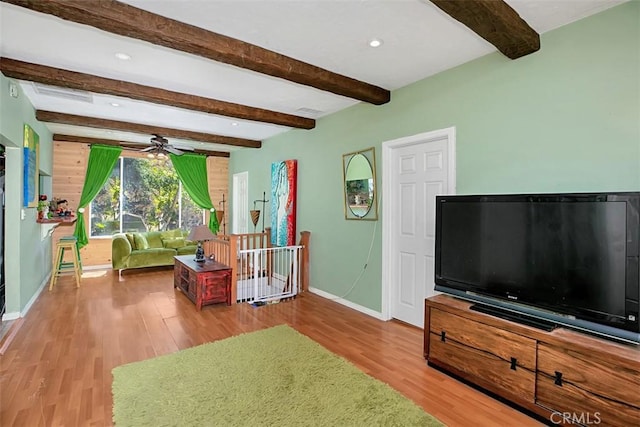 living room featuring beam ceiling, light wood-type flooring, and ceiling fan