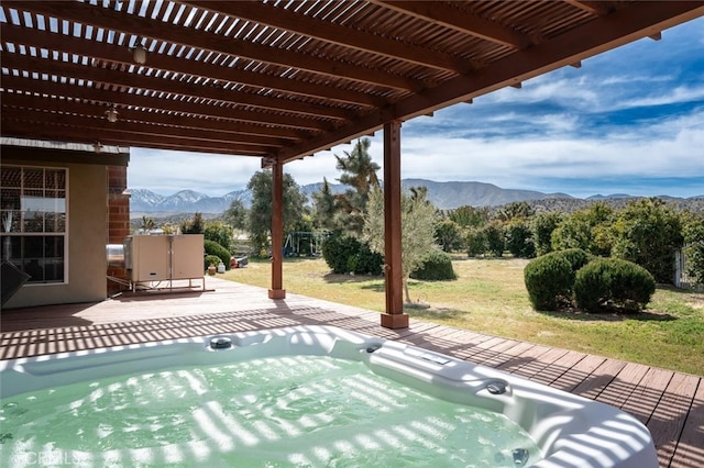 view of swimming pool with a hot tub, a mountain view, a pergola, and a yard