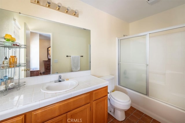 full bathroom with enclosed tub / shower combo, tile patterned flooring, vanity, and toilet