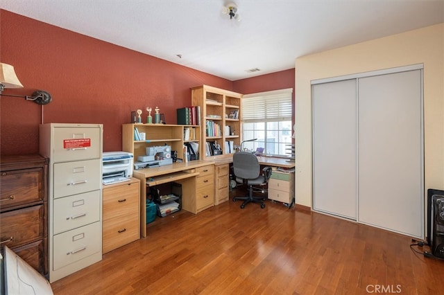 home office with light hardwood / wood-style flooring