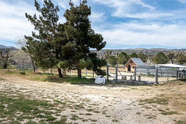 view of yard with a mountain view, a rural view, and an outbuilding