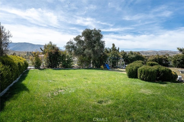 view of yard with a playground and a mountain view