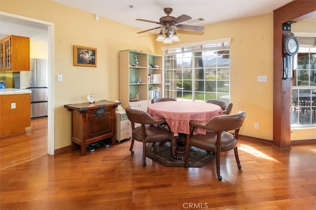 dining space with hardwood / wood-style flooring, ceiling fan, and plenty of natural light