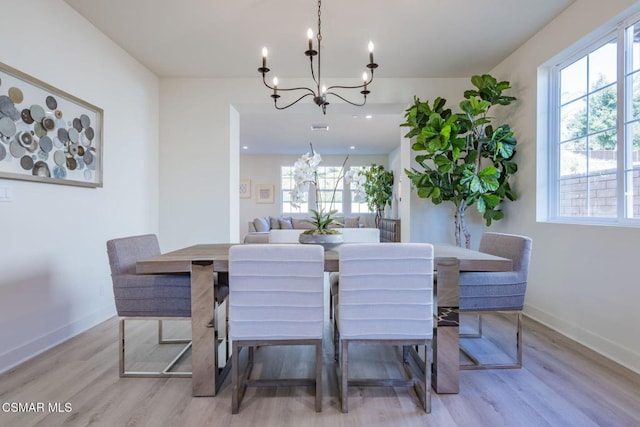 dining area with a notable chandelier and light wood-type flooring