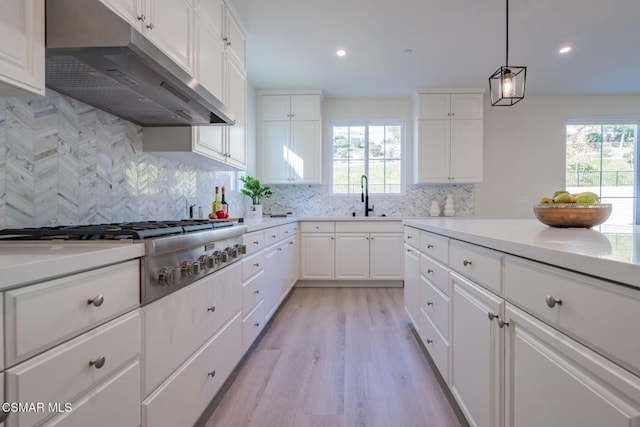 kitchen featuring white cabinetry, plenty of natural light, light hardwood / wood-style floors, and stainless steel gas cooktop