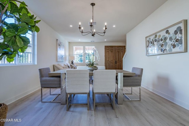 dining area featuring light wood-type flooring and a chandelier