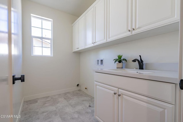 laundry room with cabinets, hookup for a washing machine, and sink