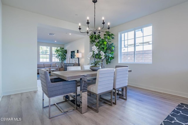 dining area featuring light hardwood / wood-style floors and a chandelier