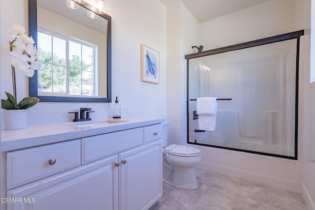 full bathroom featuring vanity, toilet, and bath / shower combo with glass door