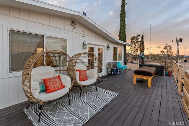 deck at dusk featuring french doors