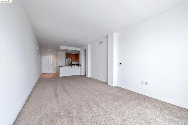 unfurnished living room featuring light colored carpet